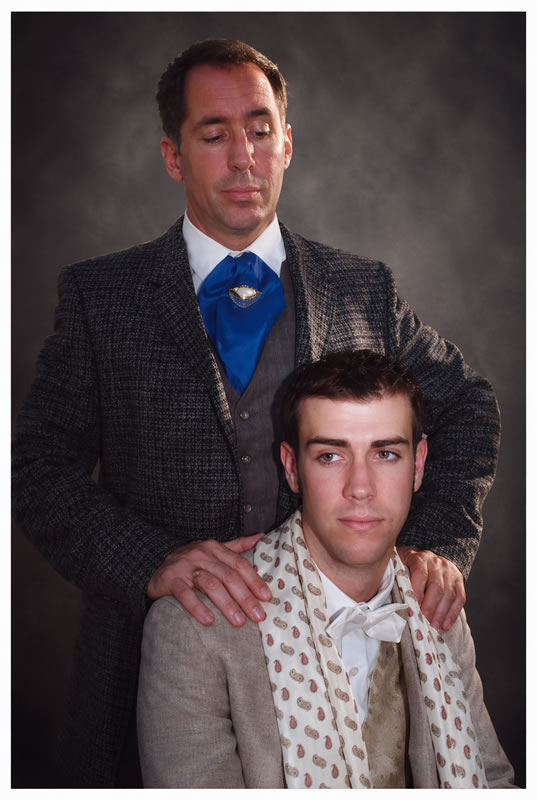 older man standing behind a younger man