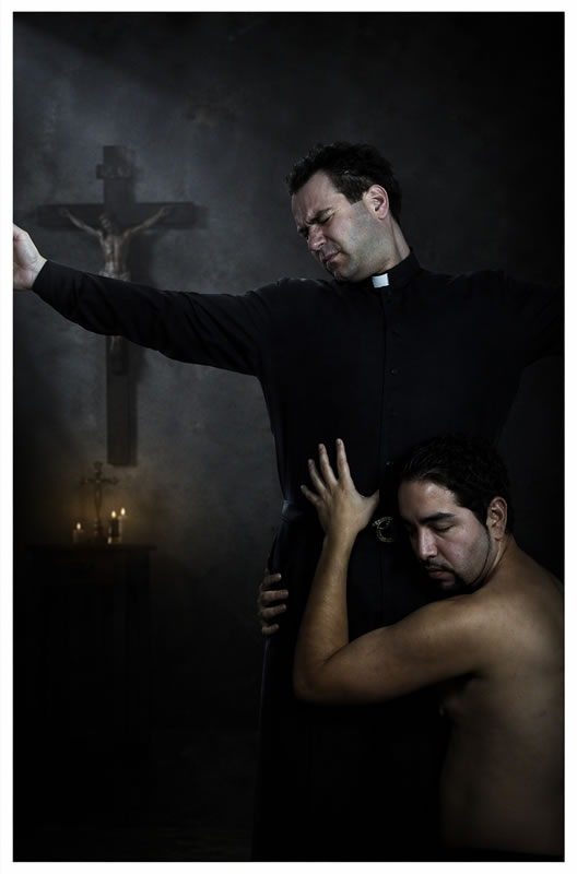 priest with arms wide and a naked man holding him