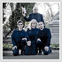 three young people kneeling in front of an older preacher
